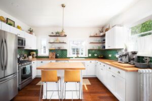 White and green color Island kitchen with wooden platforms in San Diego